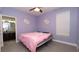 Bedroom with purple walls and gray tile flooring leads to bathroom at 12458 Fish Cove Dr, Spring Hill, FL 34609