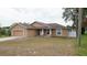 Inviting one-story home with attached garage, neutral toned paint, and covered porch featuring rocking chairs at 12458 Fish Cove Dr, Spring Hill, FL 34609