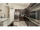 Modern kitchen with stainless steel appliances, dark cabinetry, and a granite countertop at 12458 Fish Cove Dr, Spring Hill, FL 34609