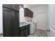 A well-organized laundry room featuring granite countertops, a washer, and dryer with stylish cabinetry and modern flooring at 12458 Fish Cove Dr, Spring Hill, FL 34609