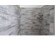 Walk-in shower featuring eye-catching wood-look tile, built-in shelving, and chrome hardware at 12458 Fish Cove Dr, Spring Hill, FL 34609