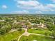 Community aerial view showcasing pool, tennis courts, golf course and clubhouse at 12920 Wedgewood Way # B, Hudson, FL 34667