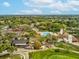 Aerial view featuring a golf course, tennis courts, pool, and community clubhouse at 12920 Wedgewood Way # B, Hudson, FL 34667