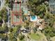 Aerial shot of community amenities, including tennis courts, pool, and golf course, nestled among trees at 12920 Wedgewood Way # B, Hudson, FL 34667