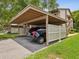 Carport with private parking, adjacent green space, and black car at 12920 Wedgewood Way # B, Hudson, FL 34667