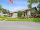 Community clubhouse featuring well-manicured lawns, mature trees, and an American flag for a welcoming ambiance at 12920 Wedgewood Way # B, Hudson, FL 34667