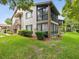 Exterior view of condo featuring a screened lanai, stairs, and well-maintained lawn at 12920 Wedgewood Way # B, Hudson, FL 34667