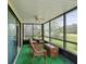 Enclosed patio with green outdoor carpet, wicker furniture, and views of the landscaped yard at 12920 Wedgewood Way # B, Hudson, FL 34667