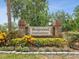 Classic brick community entrance sign surrounded by colorful plants, conveying a sense of established charm at 12920 Wedgewood Way # B, Hudson, FL 34667
