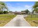 Charming single story home with a long driveway and front yard behind a chainlink fence at 12936 Parkwood St, Hudson, FL 34669