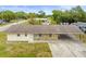 Single-story home with mixed stone and vinyl siding with a long driveway and carport at 12936 Parkwood St, Hudson, FL 34669