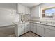 Bright kitchen featuring a window over the double sink, neutral countertops, and white cabinets at 12936 Parkwood St, Hudson, FL 34669