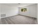 Bright living room features neutral carpet, white walls, a large window and white door for ample natural light at 12936 Parkwood St, Hudson, FL 34669