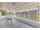 Screened-in back porch with a concrete floor, lattice siding, and a round glass table in center at 12936 Parkwood St, Hudson, FL 34669
