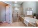 A well-lit bathroom offers a walk-in shower, soaking tub, and tiled floors for a relaxing and comfortable experience at 13248 Linzia Ln, Spring Hill, FL 34609