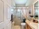 Charming bathroom features a shower with a glass door, a single vanity with storage, and a bright color scheme at 13248 Linzia Ln, Spring Hill, FL 34609