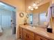 Bathroom featuring a wood vanity, large mirror, and decor with a view through the doorway at 13248 Linzia Ln, Spring Hill, FL 34609