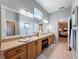 Sunlit bathroom features a large vanity with double sinks, tiled floors, and a soaking tub with views of the bedroom at 13248 Linzia Ln, Spring Hill, FL 34609