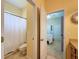 Bathroom featuring a shower with curtain, toilet, tile floor, and an open doorway to another room at 13248 Linzia Ln, Spring Hill, FL 34609