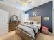 Cozy bedroom featuring a stylish wooden bed frame, ceiling fan, and accent wall, creating a comfortable retreat at 13248 Linzia Ln, Spring Hill, FL 34609