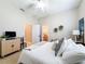 Bright bedroom featuring a ceiling fan, ensuite bathroom, and a television atop a stylish cabinet at 13248 Linzia Ln, Spring Hill, FL 34609