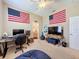 Spacious bedroom featuring American flags, a computer setup, and a beanbag chair, creating a versatile space at 13248 Linzia Ln, Spring Hill, FL 34609