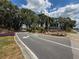 Well-maintained community entrance with colorful flower beds and mature trees at 13248 Linzia Ln, Spring Hill, FL 34609