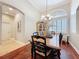 Open dining room showcasing hardwood floors, a large window with shutters, and elegant chandelier, perfect for entertaining at 13248 Linzia Ln, Spring Hill, FL 34609