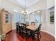 Bright dining room boasts hardwood floors, stylish chandelier, large window with shutters, and lovely built-in cabinet at 13248 Linzia Ln, Spring Hill, FL 34609