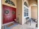 Inviting front porch with double red doors, decorative wreaths, and a comfortable bench at 13248 Linzia Ln, Spring Hill, FL 34609