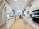 A modern kitchen with stainless appliances, white cabinets, and granite countertops offers ample space at 13248 Linzia Ln, Spring Hill, FL 34609