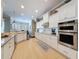 Well-lit kitchen boasts stainless steel appliances, modern cabinetry, and tile flooring at 13248 Linzia Ln, Spring Hill, FL 34609