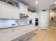 Bright white kitchen featuring tiled backsplash, granite countertops, and stainless steel appliances at 13248 Linzia Ln, Spring Hill, FL 34609