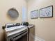 Laundry room features updated washer and dryer along with a woven basket and framed art at 13248 Linzia Ln, Spring Hill, FL 34609