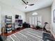 Home office featuring hardwood floors, white shutters, ceiling fan, a desk with dual monitors, and exercise equipment at 13248 Linzia Ln, Spring Hill, FL 34609