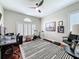 Home office with hardwood floors, a ceiling fan, a large window with shutters, and exercise equipment at 13248 Linzia Ln, Spring Hill, FL 34609