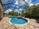 Sparkling pool with screened enclosure, lush landscaping, and inviting outdoor living space at 13248 Linzia Ln, Spring Hill, FL 34609