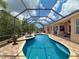 Inviting pool with screened enclosure, spa, lush landscaping, and outdoor seating for relaxation and enjoyment at 13248 Linzia Ln, Spring Hill, FL 34609