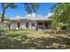 A view of the backyard showing a screened-in porch and sparse lawn at 13307 Woodward Dr, Hudson, FL 34667
