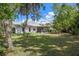 A view of the spacious backyard surrounded by trees and foliage at 13307 Woodward Dr, Hudson, FL 34667
