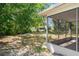 View of the wooded backyard and fire pit from the enclosed sun room at 13307 Woodward Dr, Hudson, FL 34667