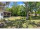 Expansive backyard with lush greenery, mature trees, and a screened porch at 13307 Woodward Dr, Hudson, FL 34667