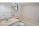 This bathroom includes a vanity, toilet, tub with shower, and a window at 13307 Woodward Dr, Hudson, FL 34667