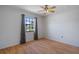 This bedroom has wood floors, a ceiling fan and a large window at 13307 Woodward Dr, Hudson, FL 34667