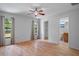 Bright main bedroom features wood floors, ceiling fan, two windows, and ensuite bathroom access at 13307 Woodward Dr, Hudson, FL 34667