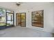 Enclosed sun room leads to the kitchen with plentiful lighting and a ceiling fan at 13307 Woodward Dr, Hudson, FL 34667