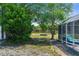 Landscaped backyard featuring a fire pit and wooden fence line, visible from screened-in pool area at 14031 Hexam Rd, Brooksville, FL 34613