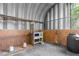 Barn interior with metal and wood walls; barrel for rainwater collection at 14031 Hexam Rd, Brooksville, FL 34613