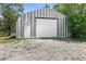 Exterior view of a metal barn with a roll-up door and additional entrance door at 14031 Hexam Rd, Brooksville, FL 34613