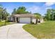 A bright home showing a driveway, landscaping, and attached two car garage at 14031 Hexam Rd, Brooksville, FL 34613